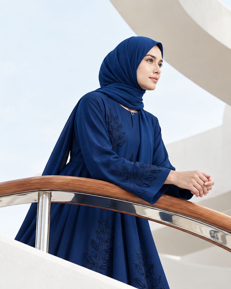 The Neelam Leaf Abaya, worn on a white staircase